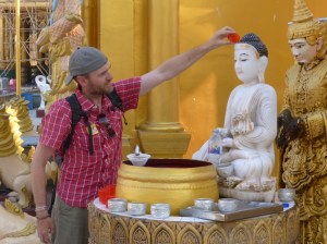 Dean pouring water over the Buddha image for his birth day of the week