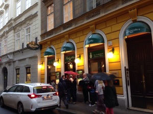 People lining up on a rainy night in Vienna